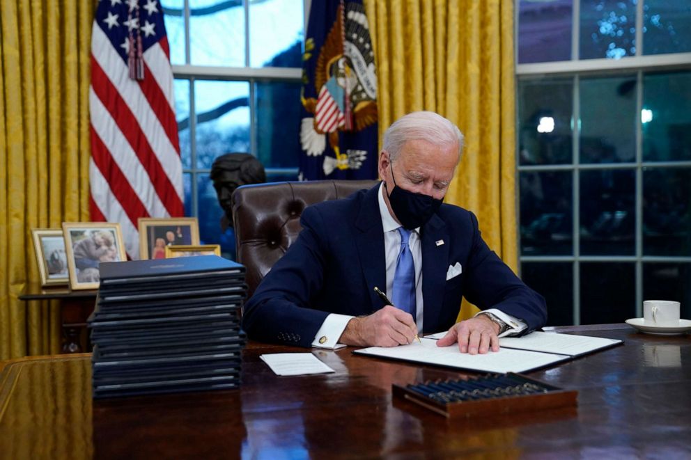 PHOTO: President Joe Biden signs his first executive order in the Oval Office of the White House in Washington, Jan. 20, 2021.