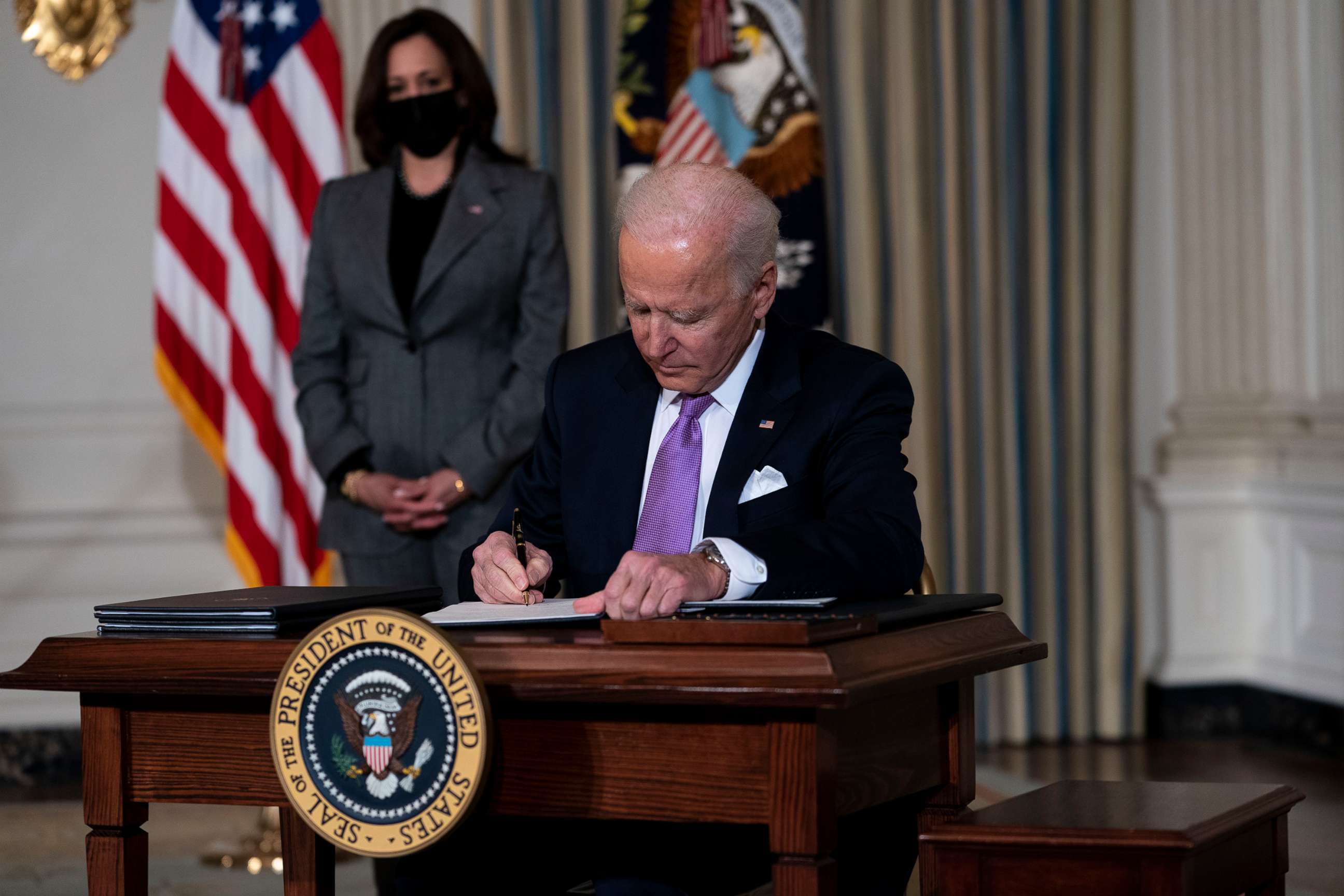 PHOTO: Vice President Kamala Harris looks on as President Joe Biden signs executives orders related to his racial equity agenda in the State Dining Room of the White House, Jan. 26, 2021.