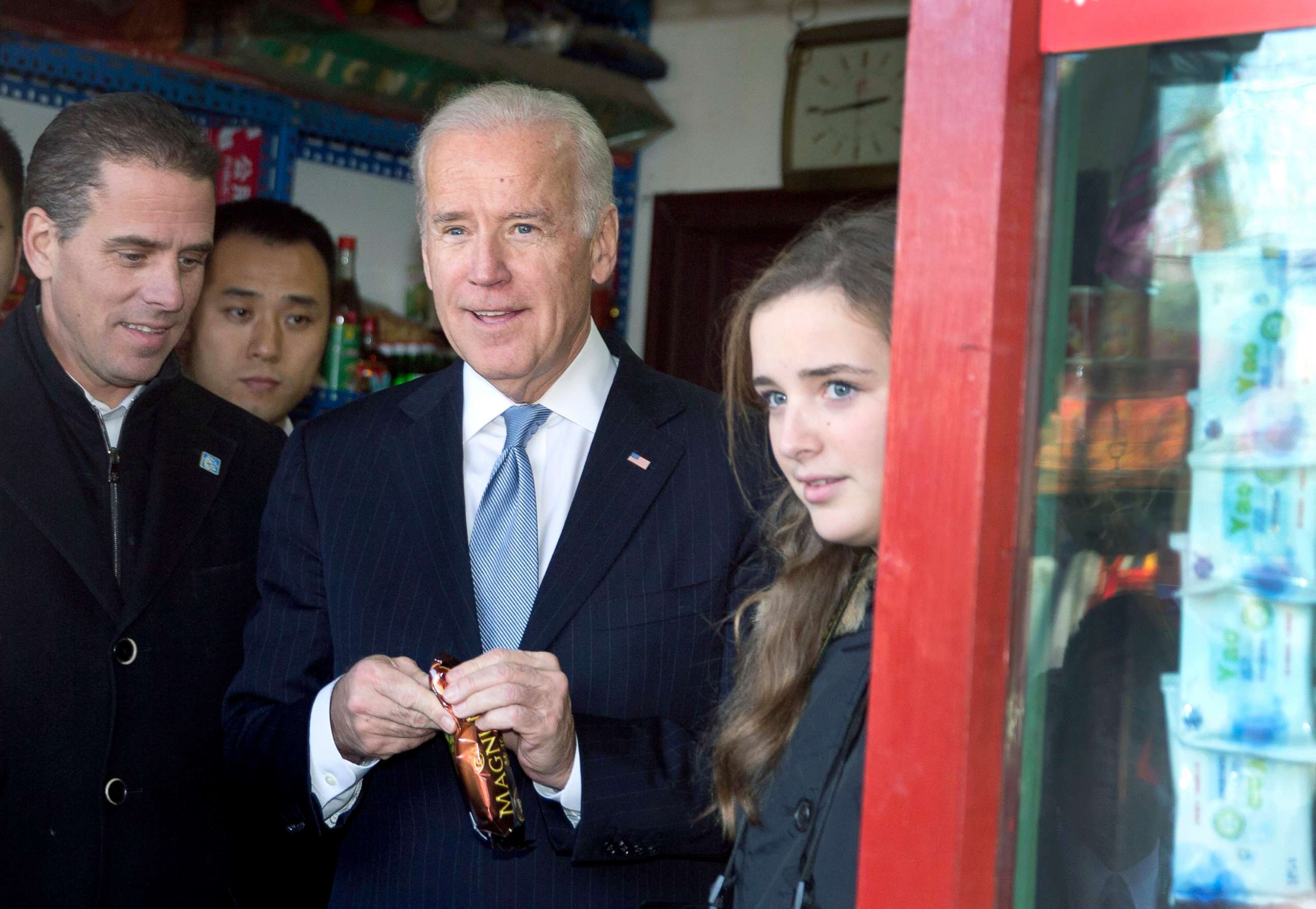 PHOTO: Vice President Joe Biden, center, buys an ice-cream at a shop as he tours a Hutong alley with his granddaughter Finnegan Biden, right, and son Hunter Biden, left, in Beijing, China, Dec. 5, 2013.