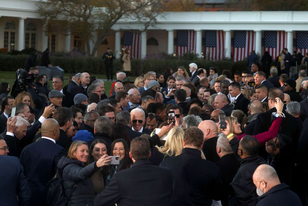 PHOTO: People greet each other and President Joe Biden, center, after a ceremony to sign the "Infrastructure Investment and Jobs Act", at the White House, Nov. 15, 2021.
