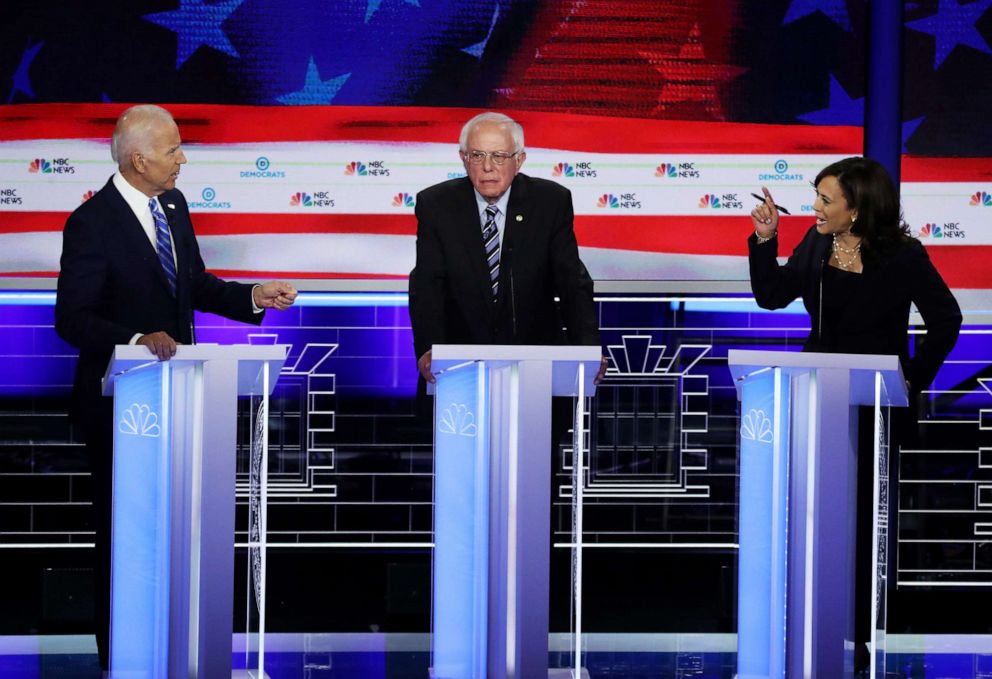 PHOTO: Sen. Kamala Harris and former Vice President Joe Biden speak as Sen. Bernie Sanders looks on during the second night of the first Democratic presidential debate, June 27, 2019, in Miami, Florida.