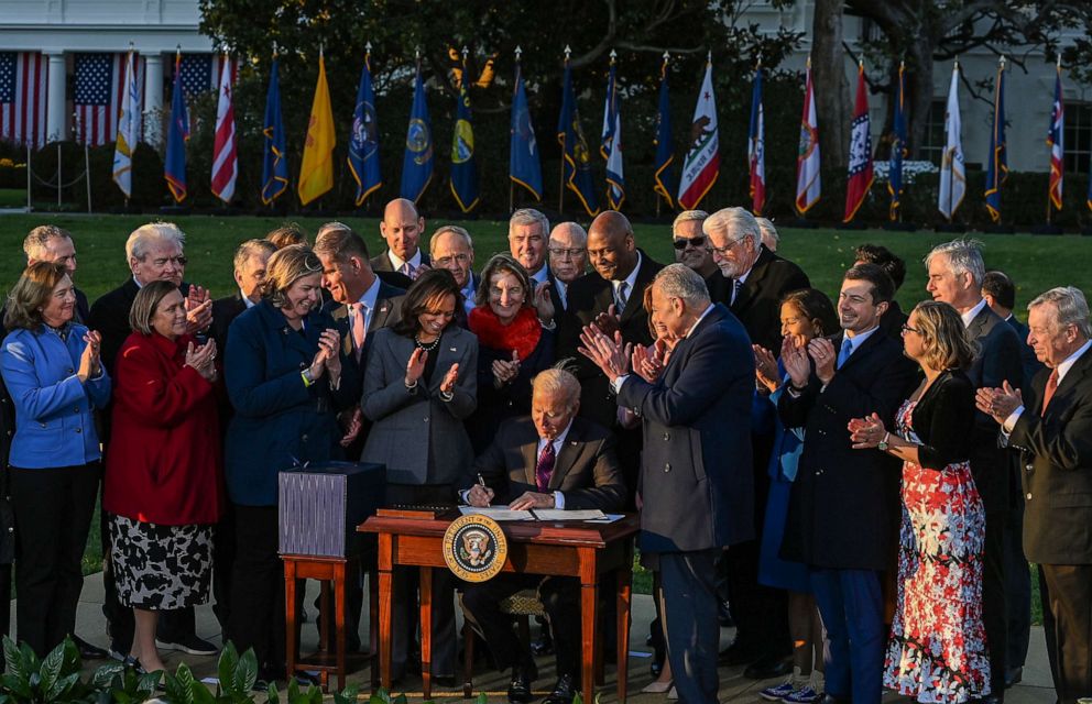 PHOTO: President Joe Biden signs the Infrastructure Investment and Jobs Act, surrounded by lawmakers and members of his Cabinet, during a ceremony on the South Lawn at the White House on Nov. 15, 2021, in Washington.
