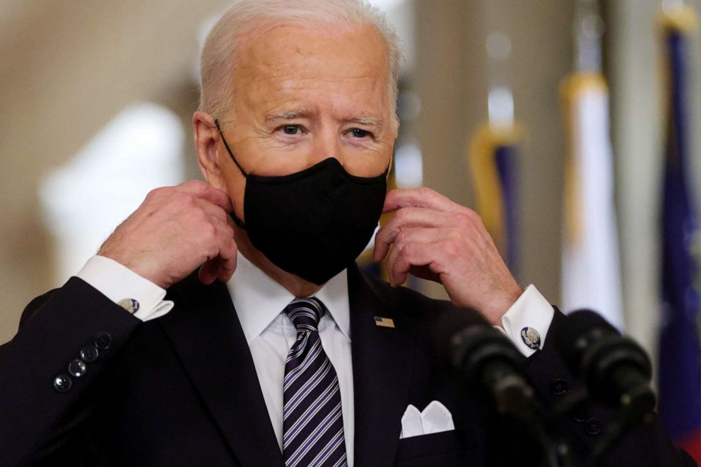 PHOTO: President Joe Biden takes off his mask before delivering a prime-time address to the nation from the East Room of the White House March 11, 2021, in Washington, D.C.