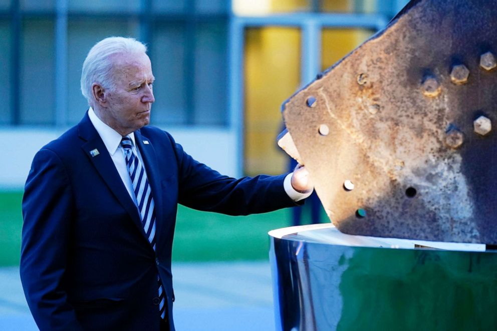 PHOTO: President Joe Biden touches a piece of steel from the North Tower of the World Trade Center while visiting a memorial to the September 11 terrorist attacks at NATO headquarters in Brussels, June 14, 2021.