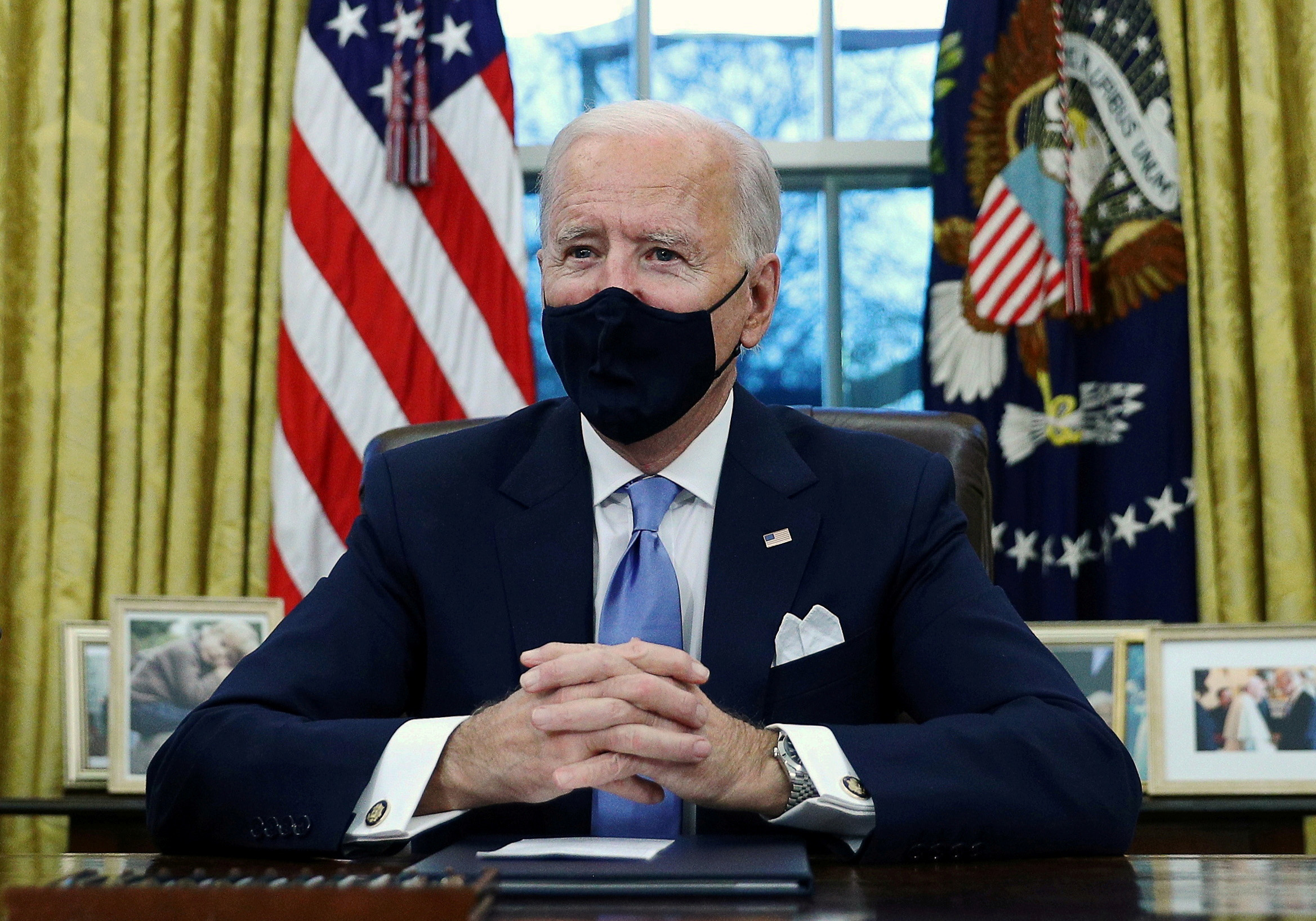 PHOTO: President Joe Biden signs executive orders in the Oval Office of the White House in Washington, Jan. 20, 2021.