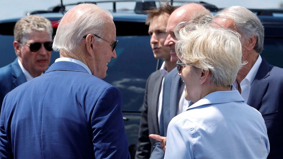 PHOTO: President Joe Biden interacts with Senator Elizabeth Warren and other elected officials after arriving at T.F. Green International Airport in Warwick, R.I., July 20, 2022. 