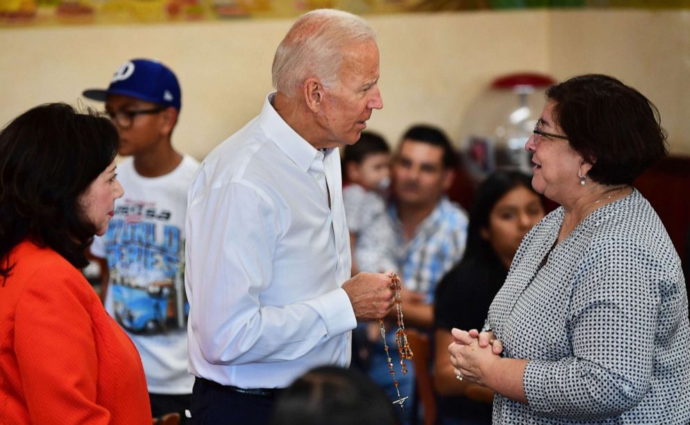 PHOTO: In this July 19, 2019, file photo, Democratic party candidate Joe Biden is given a rosary while meeting with patrons in Los Angeles.