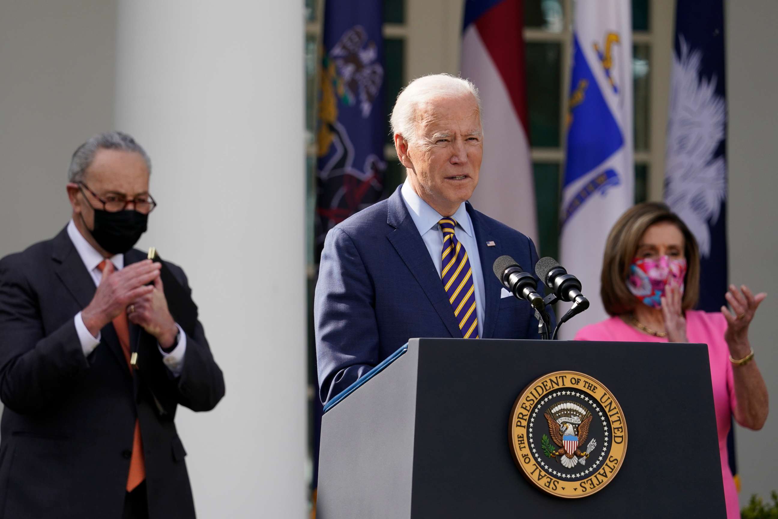 PHOTO: President Joe Biden speaks about the American Rescue Plan, a coronavirus relief package, in the Rose Garden of the White House, March 12, 2021, in Washington, D.C. Senate Majority Leader Chuck Schumer and House Speaker Nancy Pelosi listen.