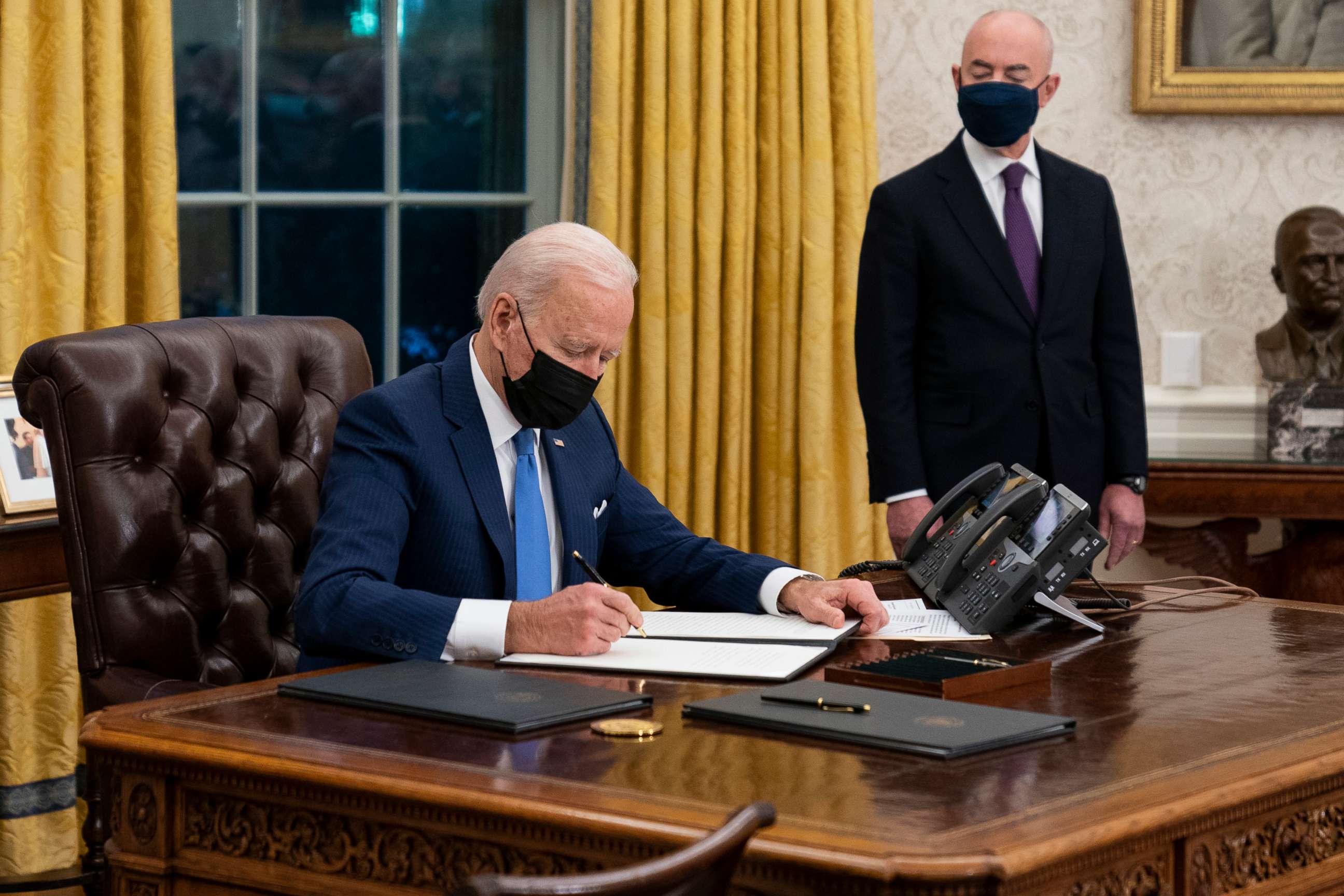 PHOTO: Secretary of Homeland Security Alejandro Mayorkas looks on as President Joe Biden signs an executive order on immigration, in the Oval Office of the White House, Feb. 2, 2021, in Washington, D.C.