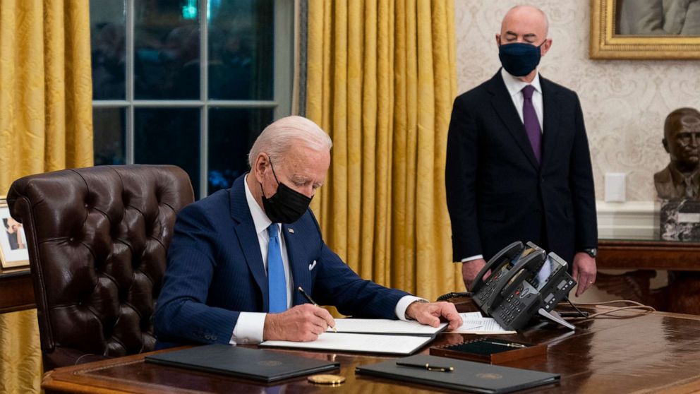 PHOTO: Secretary of Homeland Security Alejandro Mayorkas looks on as President Joe Biden signs an executive order on immigration, in the Oval Office of the White House, Feb. 2, 2021, in Washington, D.C.