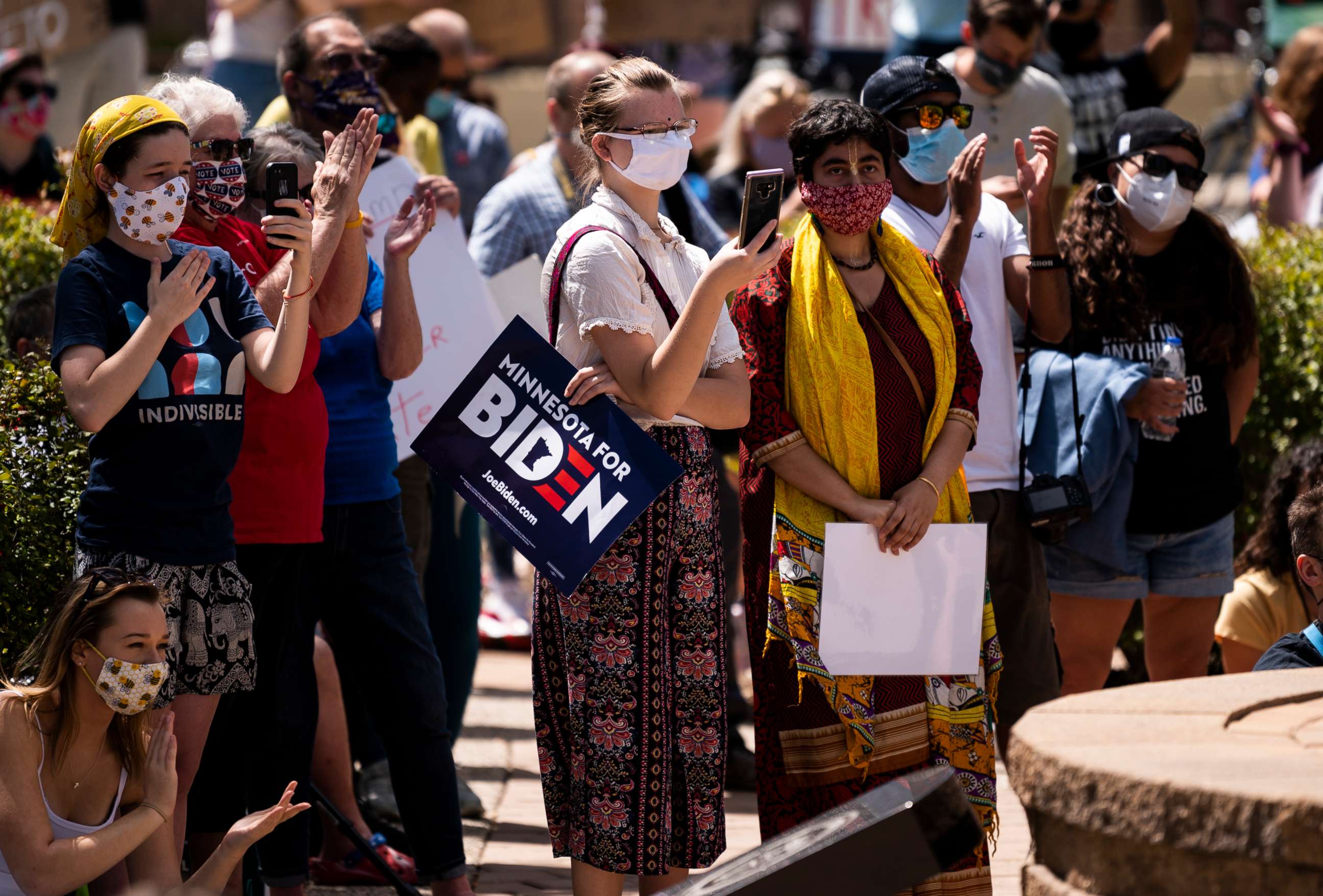PHOTO: A woman holds a sign that reads "Minnesota for Biden" as protesters gather in downtown while President Donald Trump makes a campaign stop at Mankato Regional Airport on Aug. 17, 2020, in Mankato, Minn.