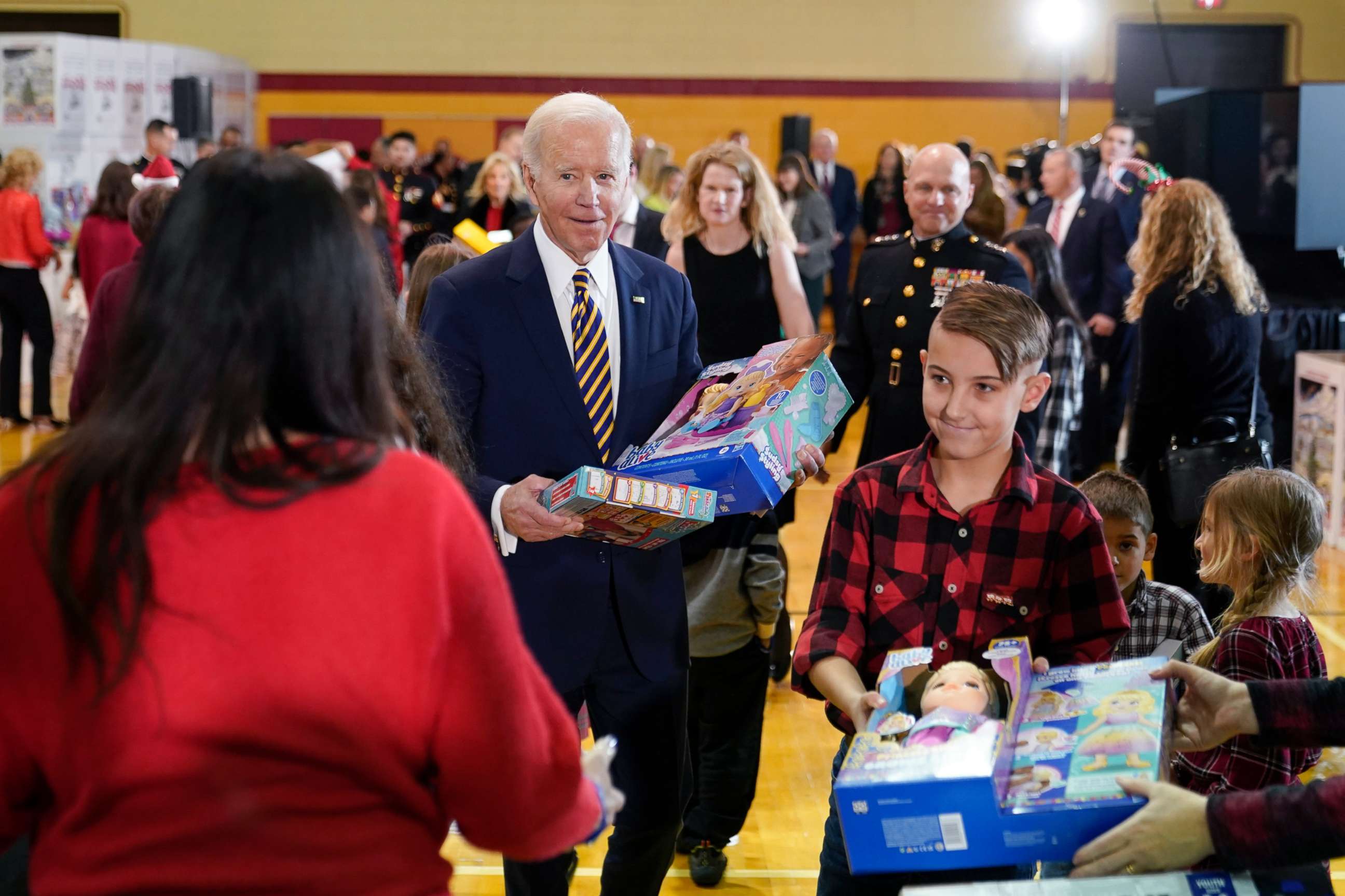 PHOTO: President Joe Biden helps children move donated toys to bins during a Toys for Tots event at Joint Base Myer-Henderson Hall in Arlington, Va., on Dec. 12, 2022. 