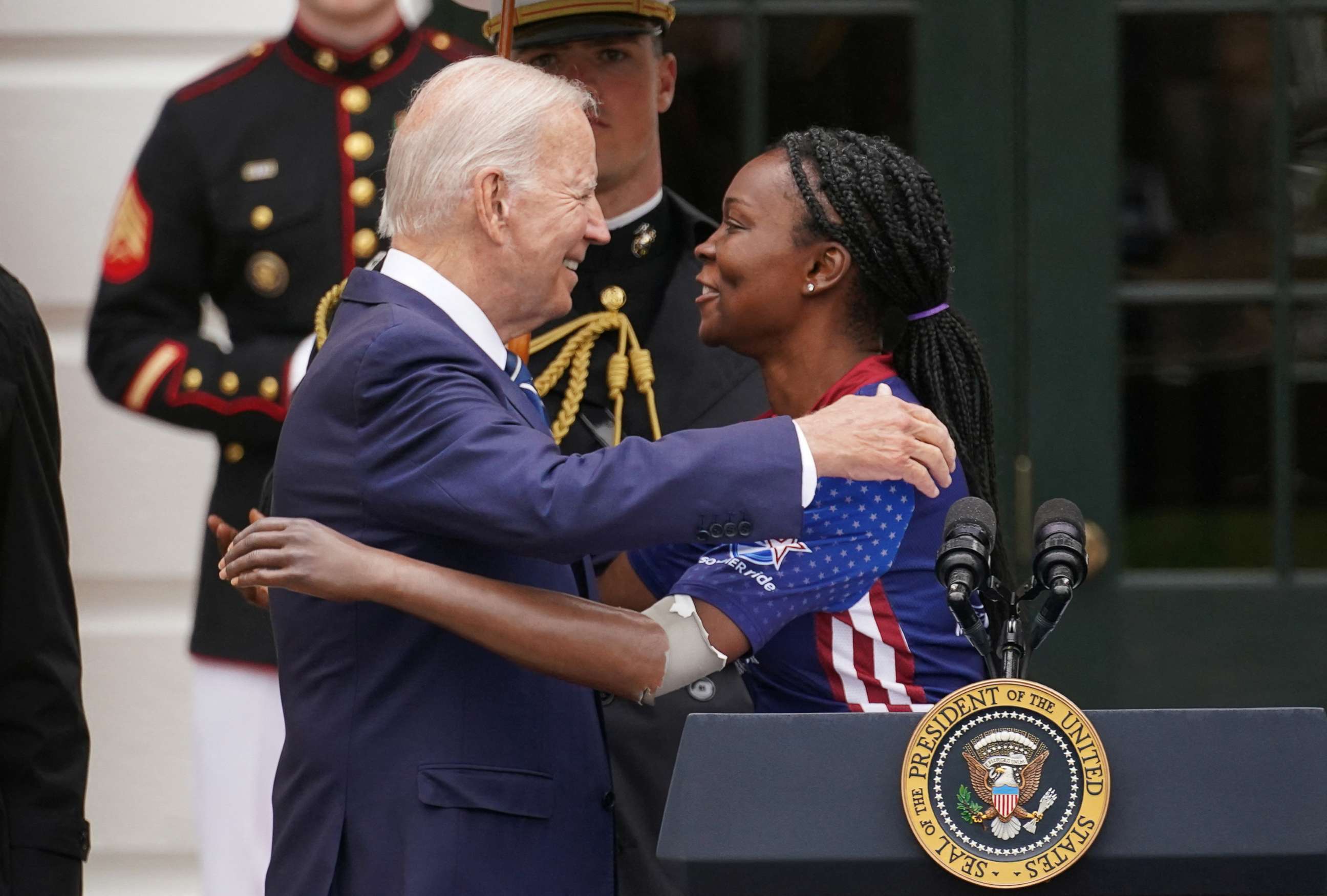 PHOTO: President Joe Biden hugs Danielle Green, a soldier who lost her arm while serving in Iraq, during an event welcoming participants in the Wounded Warrior Project Soldier Ride, at the White House in Washington, June 23, 2022.
