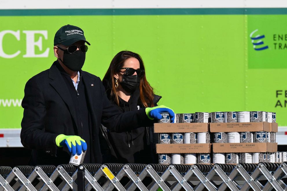 PHOTO: President-elect Joe Biden stands along a conveyor belt set up in the outside parking lot, packing up food donations at Philabundance, Philadelphia's largest hunger relief organization in Philadelphia, Jan. 18, 2021.