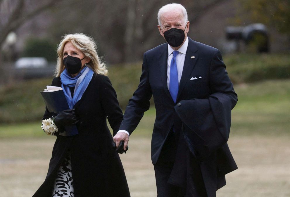 PHOTO: President Joe Biden and first lady Jill Biden walk across the South Lawn together after arriving on Marine One from a weekend at Camp David to the White House in Washington, Feb. 14, 2022.