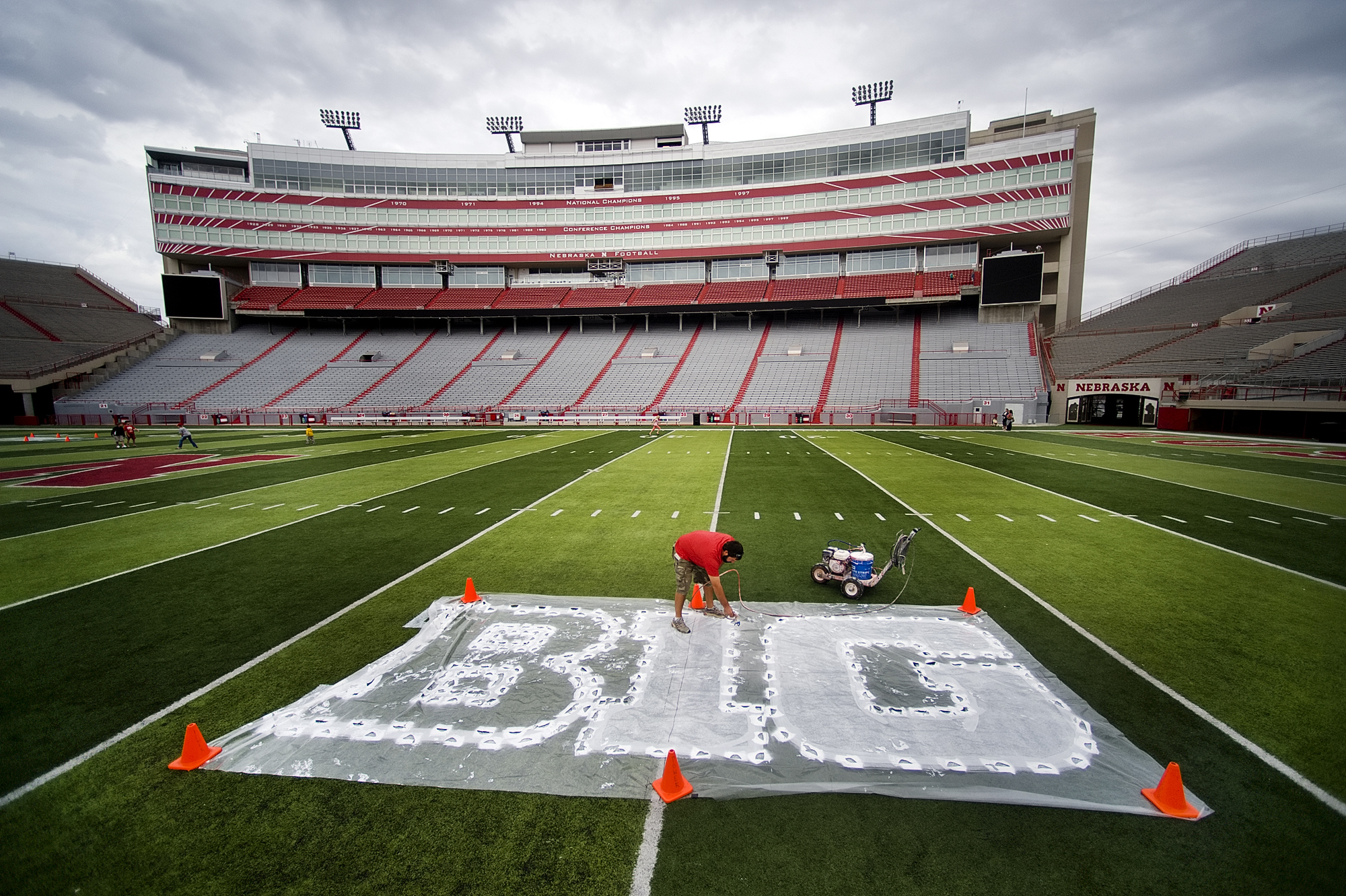 PHOTO: Turf manager Jared Hertzel touches up the newly-painted Big Ten conference logo on the football field at Memorial Stadium in Lincoln, Neb., Oct. 6, 2011.