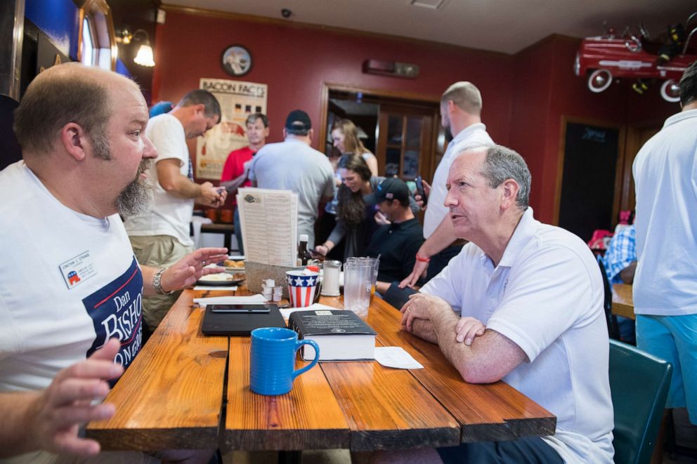 PHOTO: Dan Bishop, right, Republican candidate for North Carolina's 9th District, talks with supporters at Robin's On Main diner in Hope Mills, N.C., on Saturday, August 10, 2019.