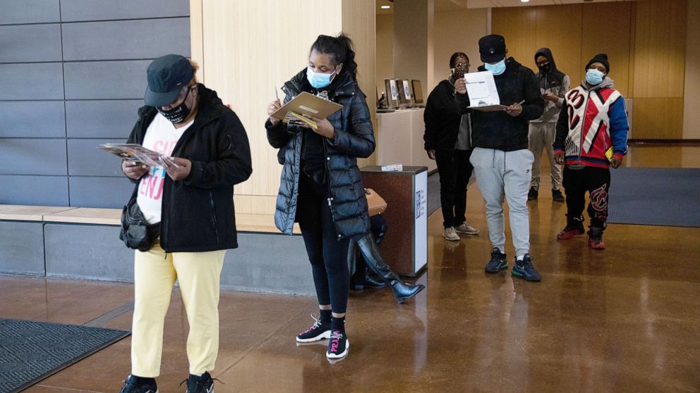 PHOTO: Voters wearing protective masks wait in line to cast ballots at a polling location for the 2020 Presidential election in Detroit, Nov. 3, 2020.