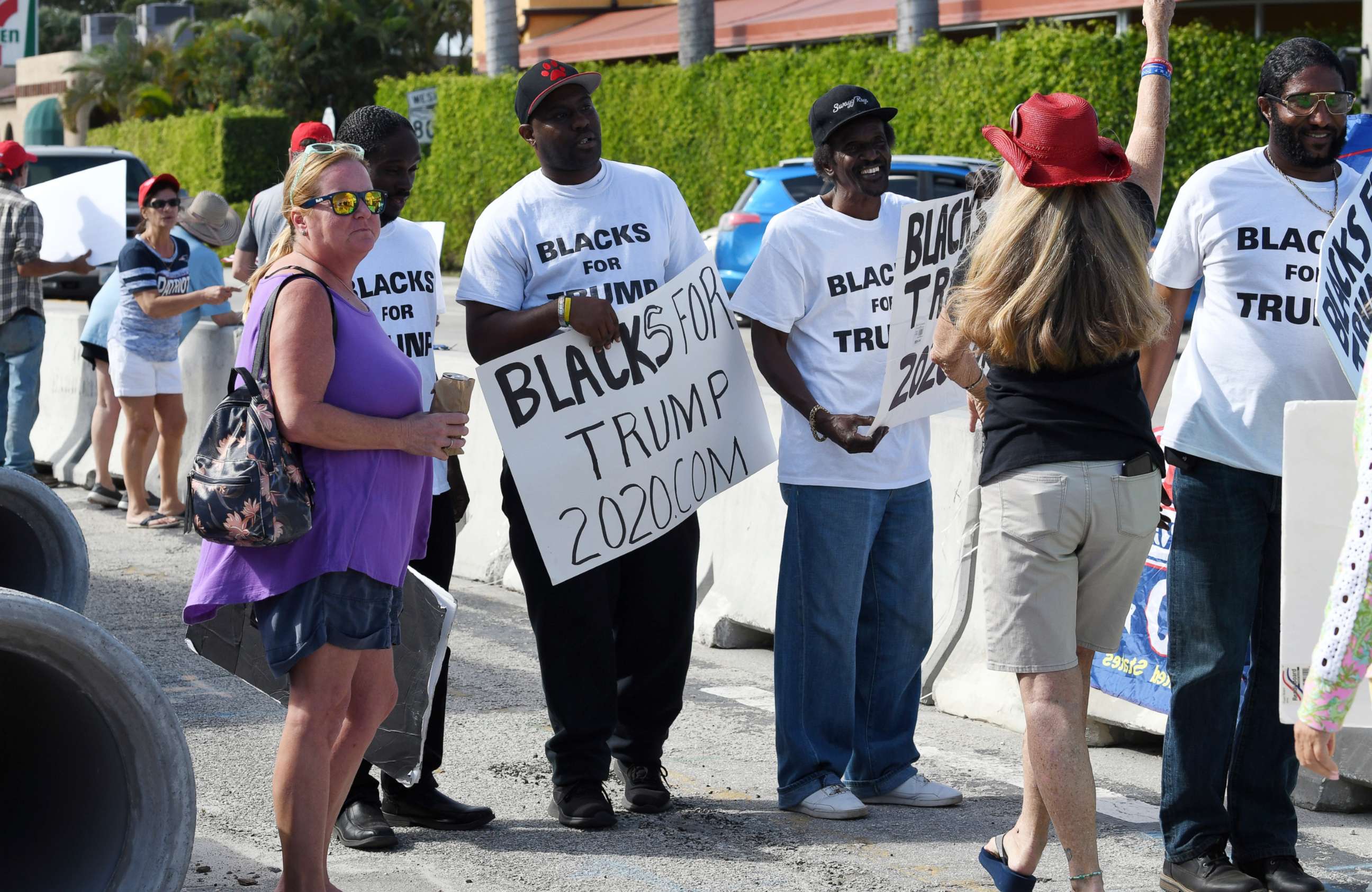 PHOTO: People holding "Blacks for Trump" signs gather along Southern Boulevard as President Donald Trump's motorcade returns to Mar-a-Lago from the Trump International Golf Club located in West Palm Beach, Jan. 18, 2020