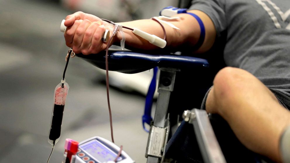 PHOTO: A man donates blood at a temporary blood bank set up in a church's fellowship hall, March 24, 2020, in Tempe, Ariz.