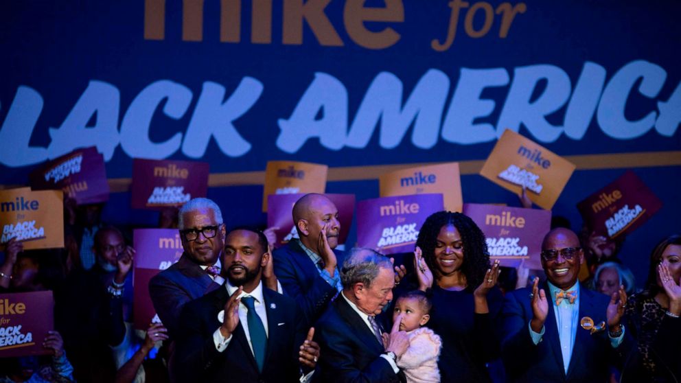 PHOTO: TOPSHOT - Democratic presidential hopeful Mike Bloomberg (C) holds a baby during the "Mike for Black America Launch Celebration" at the Buffalo Soldier National Museum in Houston, Texas, on February 13, 2020. 