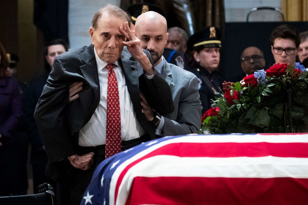 PHOTO: Former Senator Bob Dole stands up and salutes the casket of the late former President George H.W. Bush as he lies in state at the U.S. Capitol, December 4, 2018, in Washington, D.C.