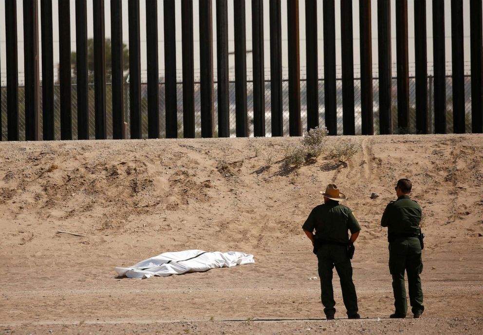 PHOTO: U.S. Border Patrol agents observe the body of a person covered in a white sheet near the border wall in El Paso, Texas, as seen from Ciudad Juarez, Mexico, June 11, 2021.