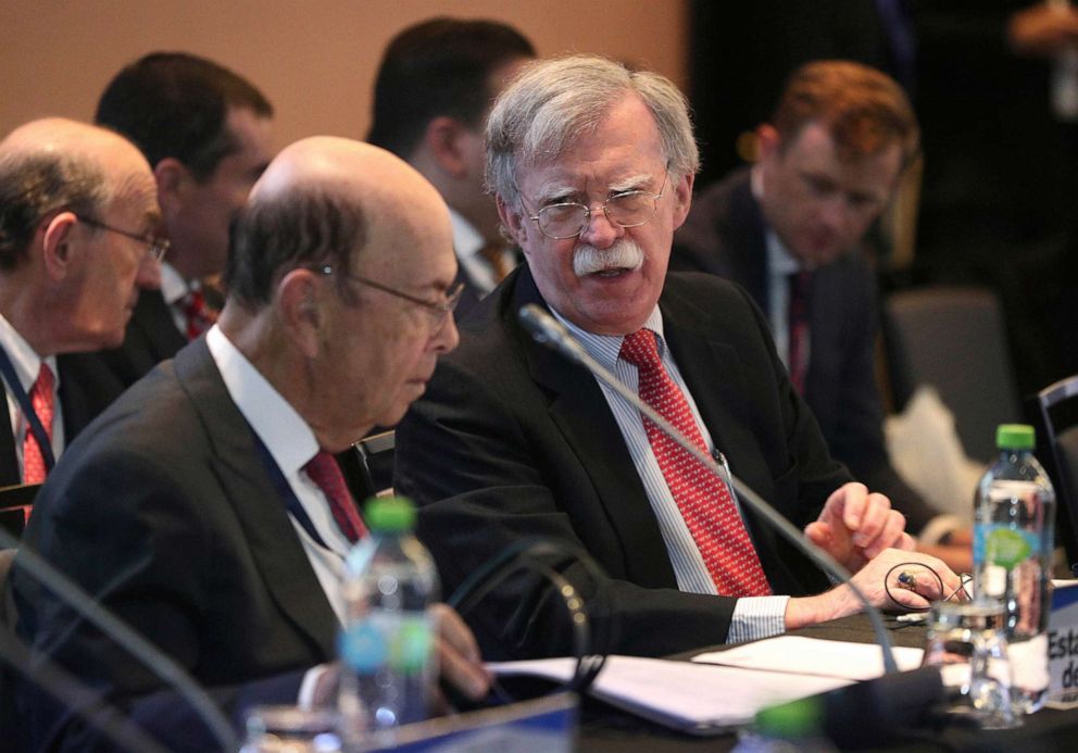 PHOTO: National security adviser John Bolton, right, speaks with U.S. Commerce Secretary Wilbur Ross during a conference of more than 50 nations that largely support opposition leader Juan Guaido in Lima, Peru, Aug. 6, 2019.