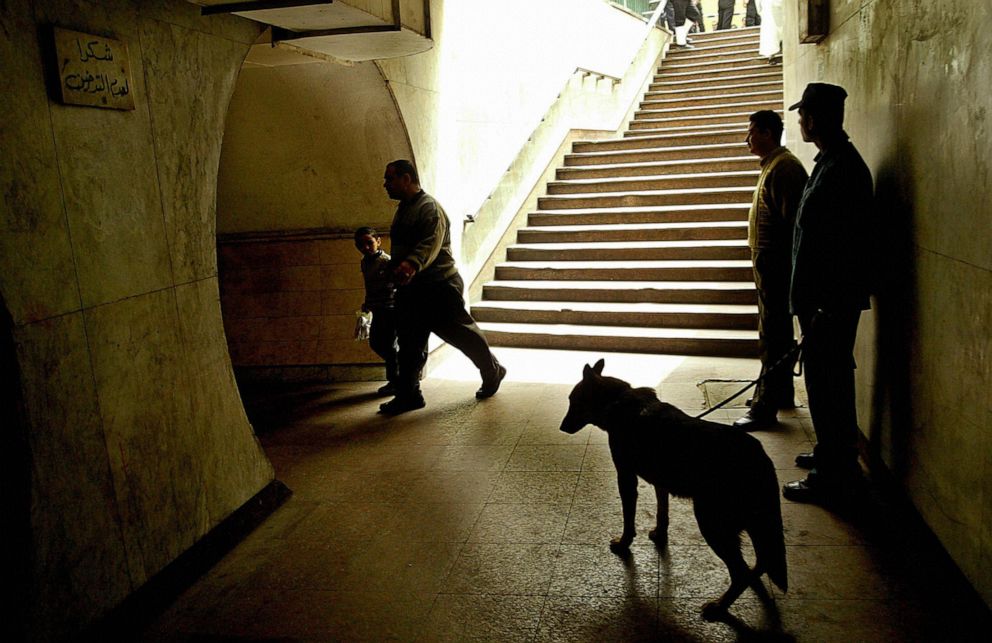 PHOTO: Egyptian policemen with a explosive sniffing dog secure a pedestrian tunnel located near the site of a bomb attack in Cairo, April 8, 2005.