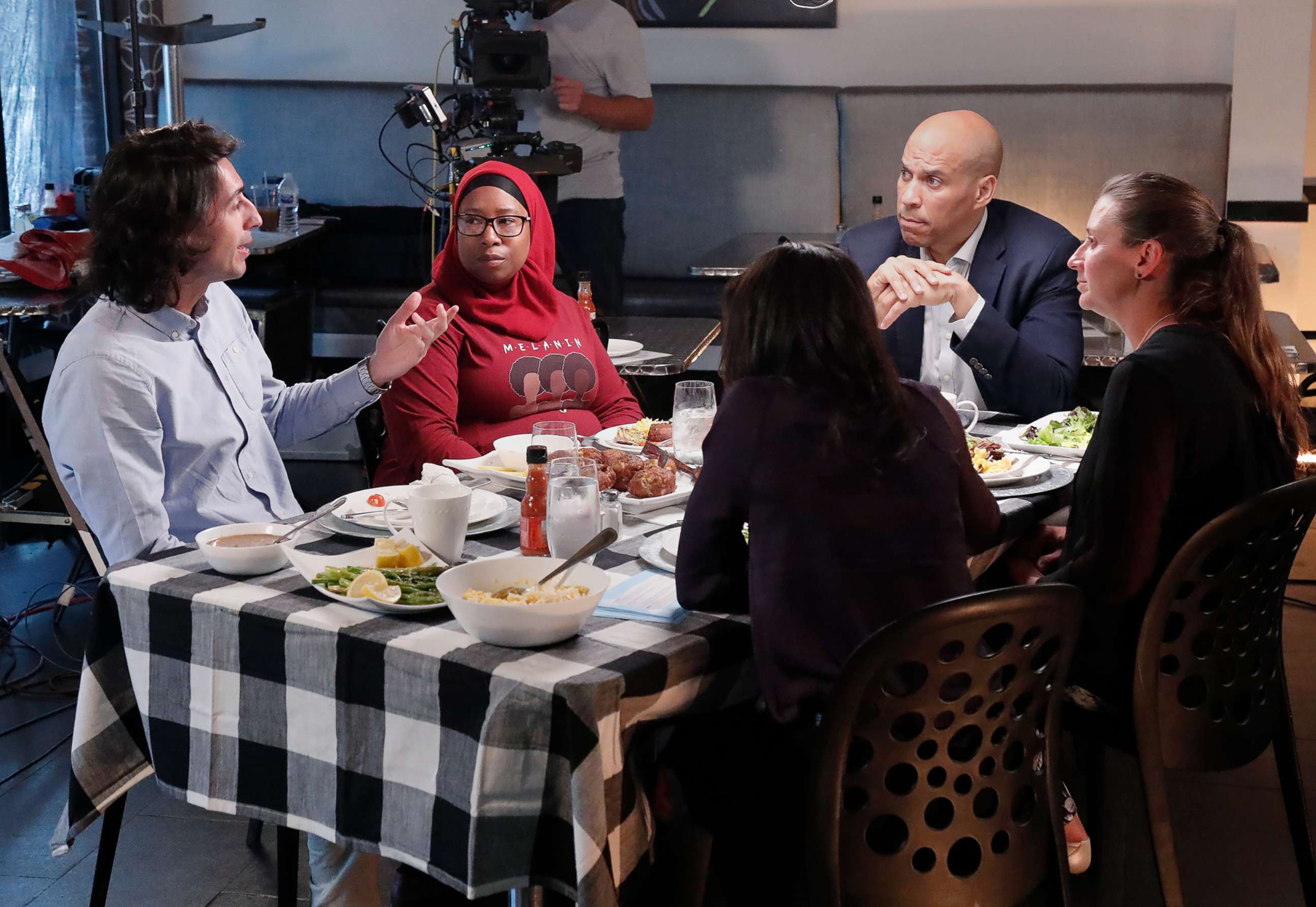 PHOTO: Bijan Roghanchi,left asks a question during a dinner with other voters and Democratic presidential candidate Cory Booker at a restaurant in Newark, N.J.