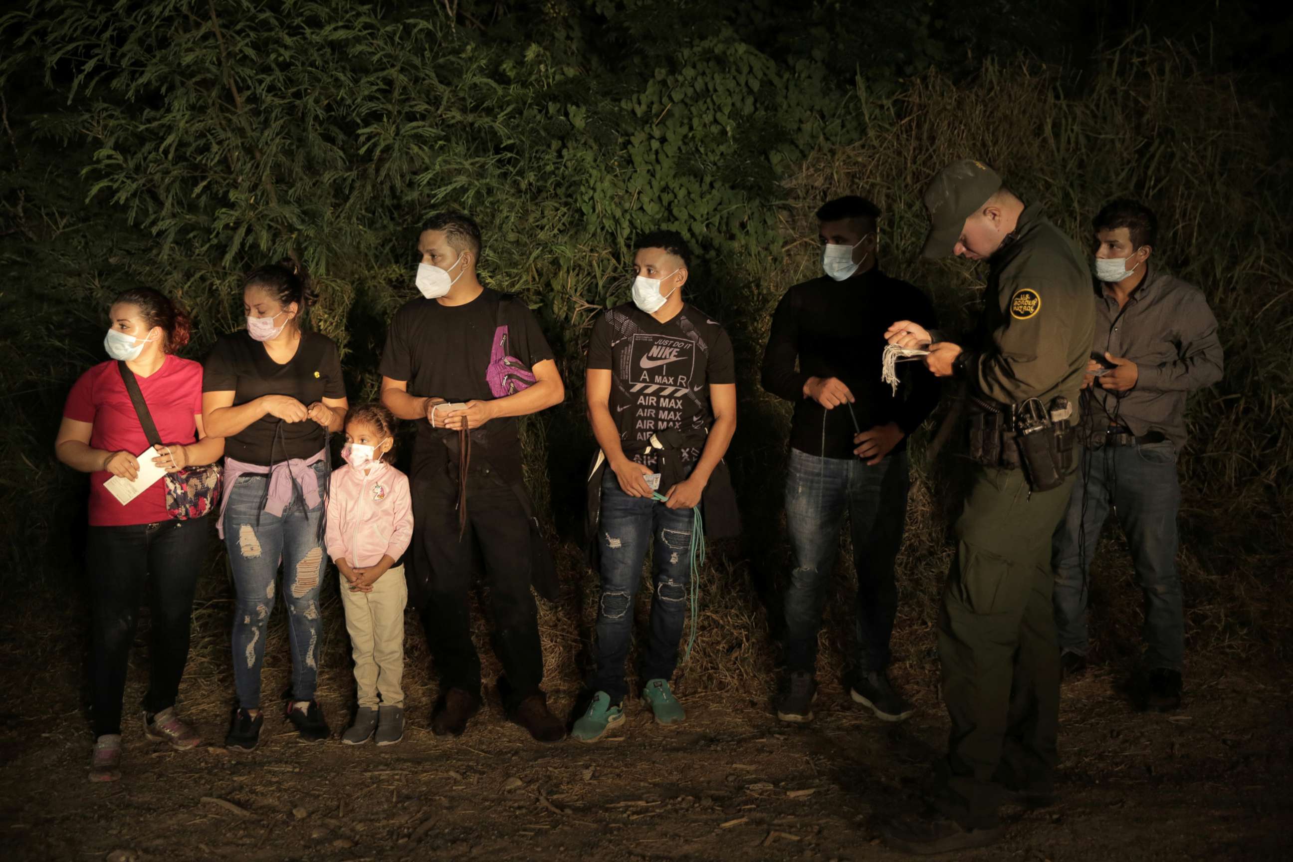 PHOTO: Migrants are lined up and processed by Border Patrol north of the Roma Ciudad Miguel Aleman International Bridge, which spans the Rio Grande border with Mexico, in Roma, Texas, Oct. 1, 2021. 