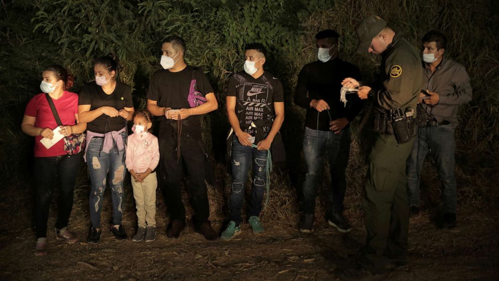 PHOTO: Migrants are lined up and processed by Border Patrol north of the Roma Ciudad Miguel Aleman International Bridge, which spans the Rio Grande border with Mexico, in Roma, Texas, Oct. 1, 2021.