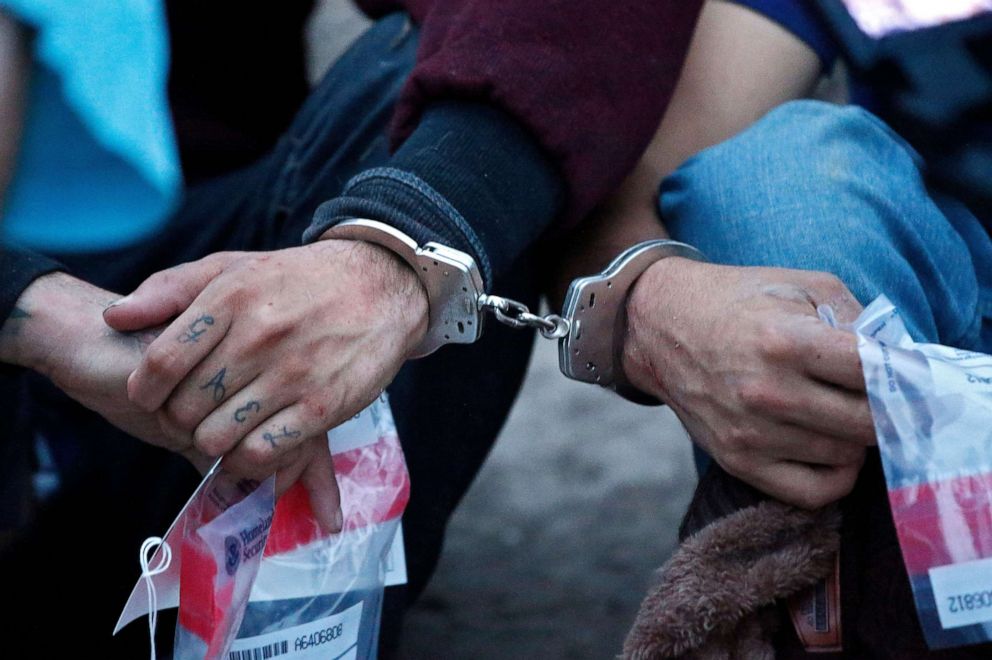 PHOTO: People suspected of crossing the border to enter the United States illegally, sit with their hands cuffed after being apprehended by U.S. Border Patrol agents near McAllen, Texas, March 4, 2020.
