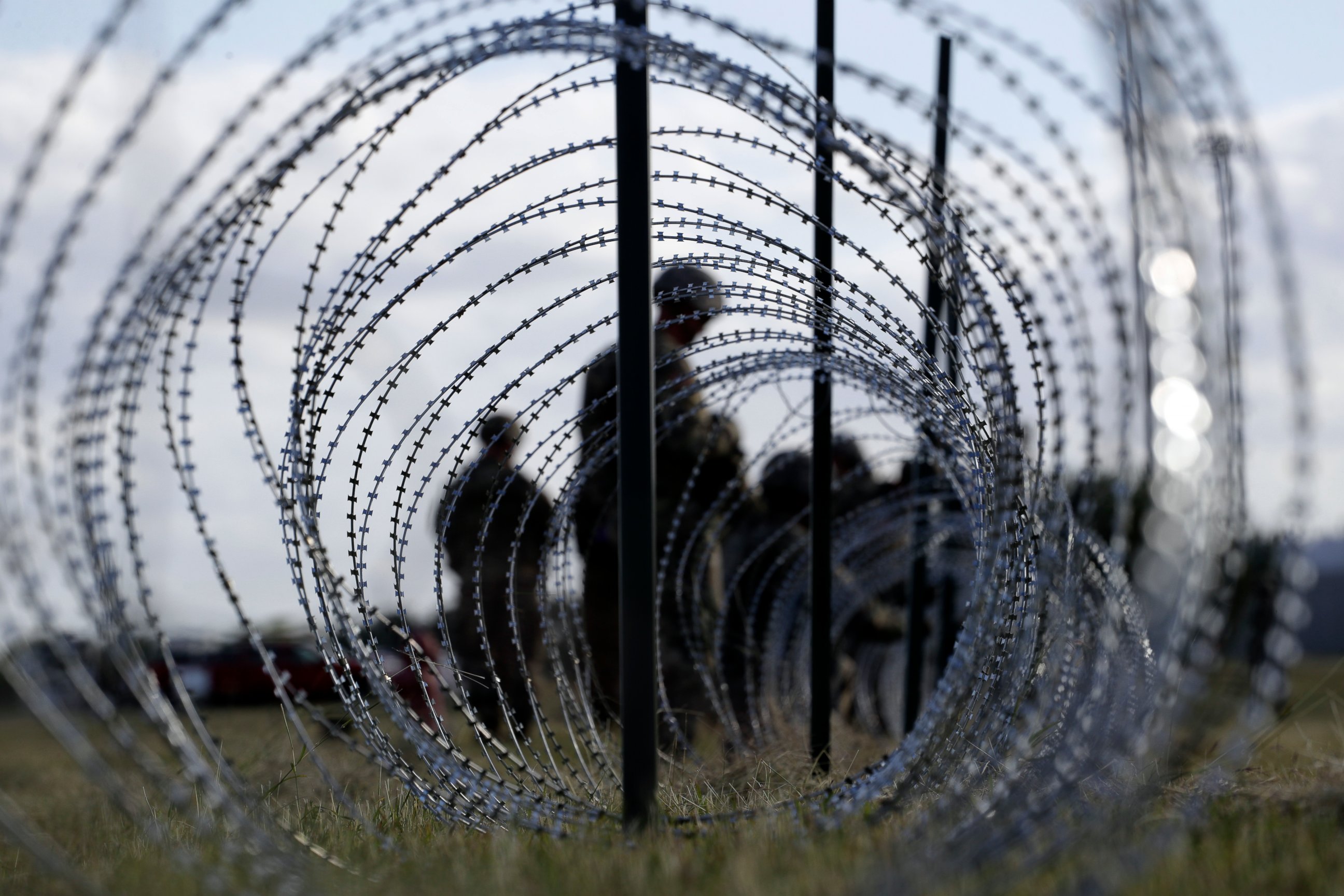 PHOTO: In this Nov. 3, 2018, file photo, members of the U.S. Army build a razor wire fence around area for tents near the U.S.-Mexico International bridge, in Donna, Texas.