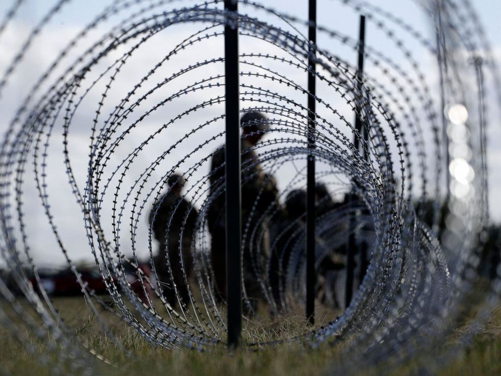 PHOTO: In this Nov. 3, 2018, file photo, members of the U.S. Army build a razor wire fence around area for tents near the U.S.-Mexico International bridge, in Donna, Texas.
