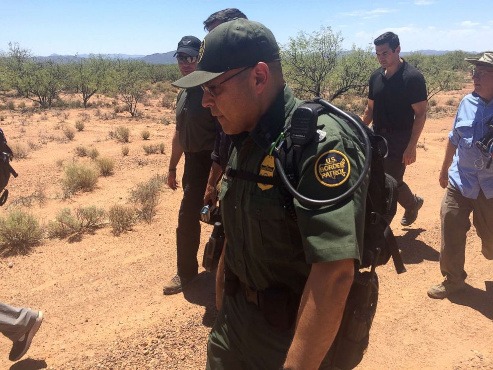 PHOTO: Customs and Border Protection Commissioner Kevin McAleenan, in sunglasses and hat, walks with a Border Patrol agent and an ABC News crew through the desert along the Arizona border. June 27, 2018.