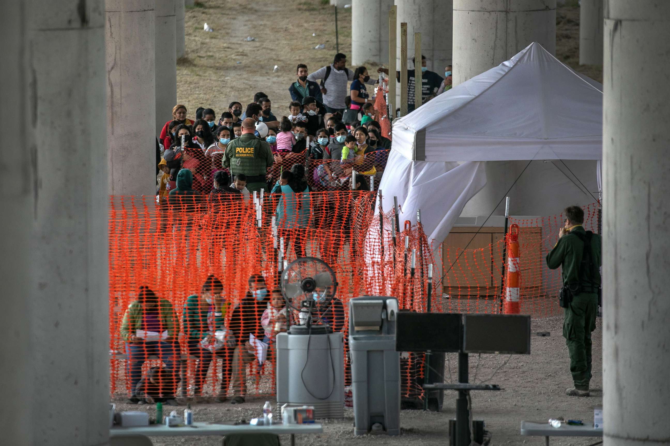 PHOTO: Asylum seekers listen to instructions at an outdoor U.S. Border Patrol processing center under the Anzalduas International Bridge after crossing the Rio Grande from Mexico, March 23, 2021 near Mission, Texas. 