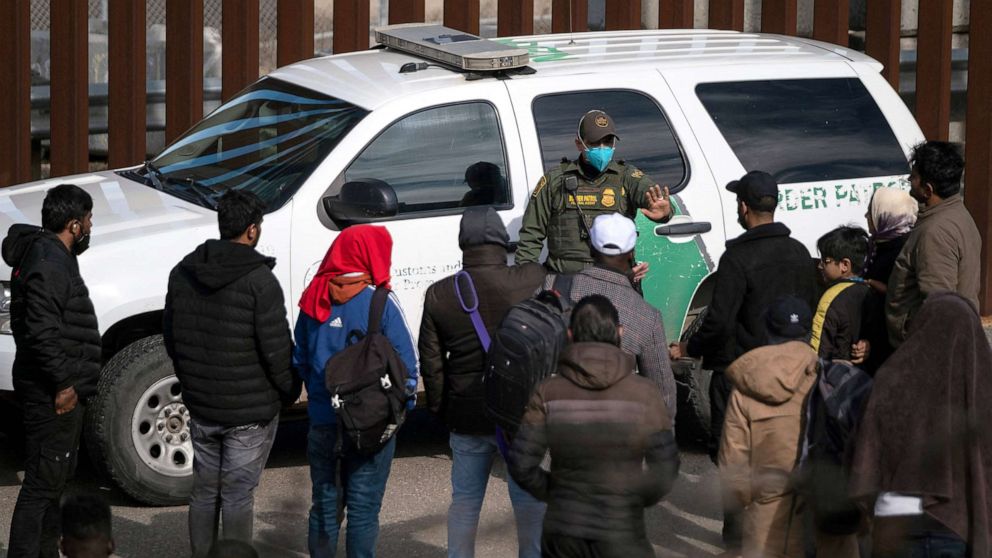 PHOTO: A border patrol agent talks to a group of migrants, mostly from African countries, before processing them after they crossed the US-Mexico border, taken from Tijuana, Baja California state, Mexico, on Nov. 11, 2022.
