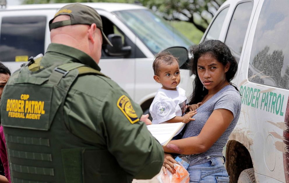 PHOTO: A mother migrating from Honduras holds her 1-year-old child after surrendering to U.S. Border Patrol agents for illegally crossing the border near McAllen, Texas, June 25, 2018.