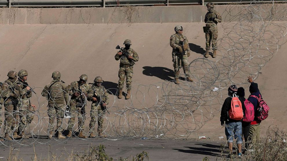 PHOTO: Migrants seeking asylum in the United States ask Texas National Guard agents to let them turn themselves in with Border Patrol agents in the El Paso, Texas border with Ciudad Juarez, Chihuahua state, Mexico, Dec. 20, 2022.