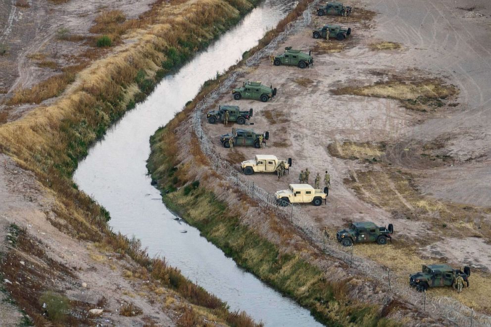 PHOTO: In an aerial view, Texas National Guard troops and state troopers line the bank of the Rio Grande after laying down concertina wire, Dec. 20, 2022 as viewed from Ciudad Juarez, Mexico.