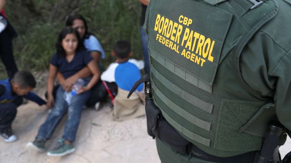 PHOTO: Central American asylum seekers wait as U.S. Border Patrol agents take them into custody, June 12, 2018 near McAllen, Texas.