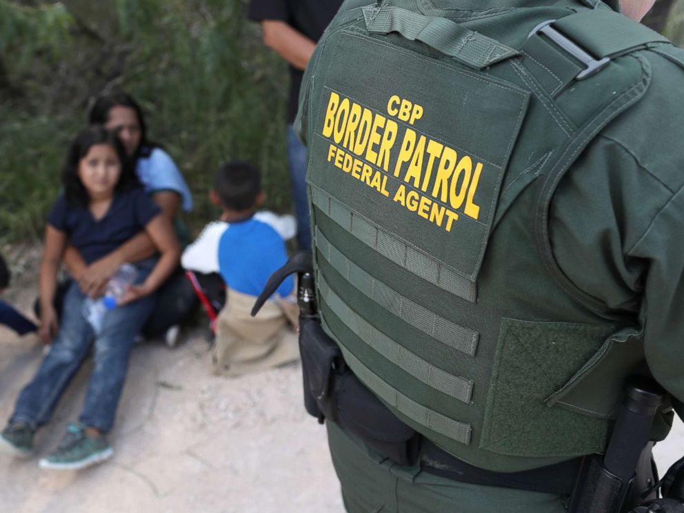 PHOTO: Central American asylum seekers wait as U.S. Border Patrol agents take them into custody, June 12, 2018 near McAllen, Texas.