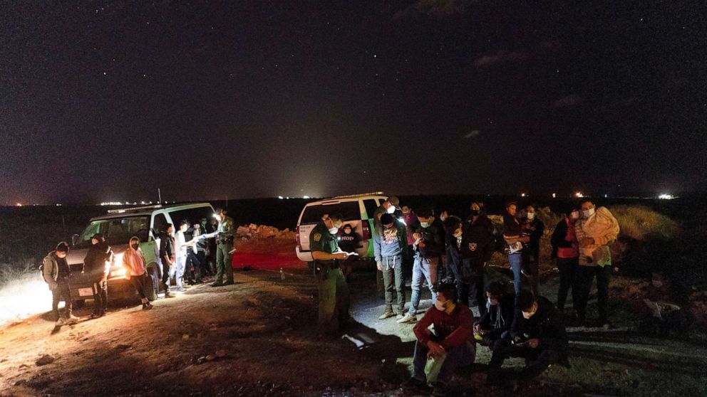 PHOTO: Asylum-seeking migrants' families wait to be transported by the U.S. Border Patrols after crossing the Rio Grande river into the United States from Mexico in Roma, Texas, April 5, 2021. 