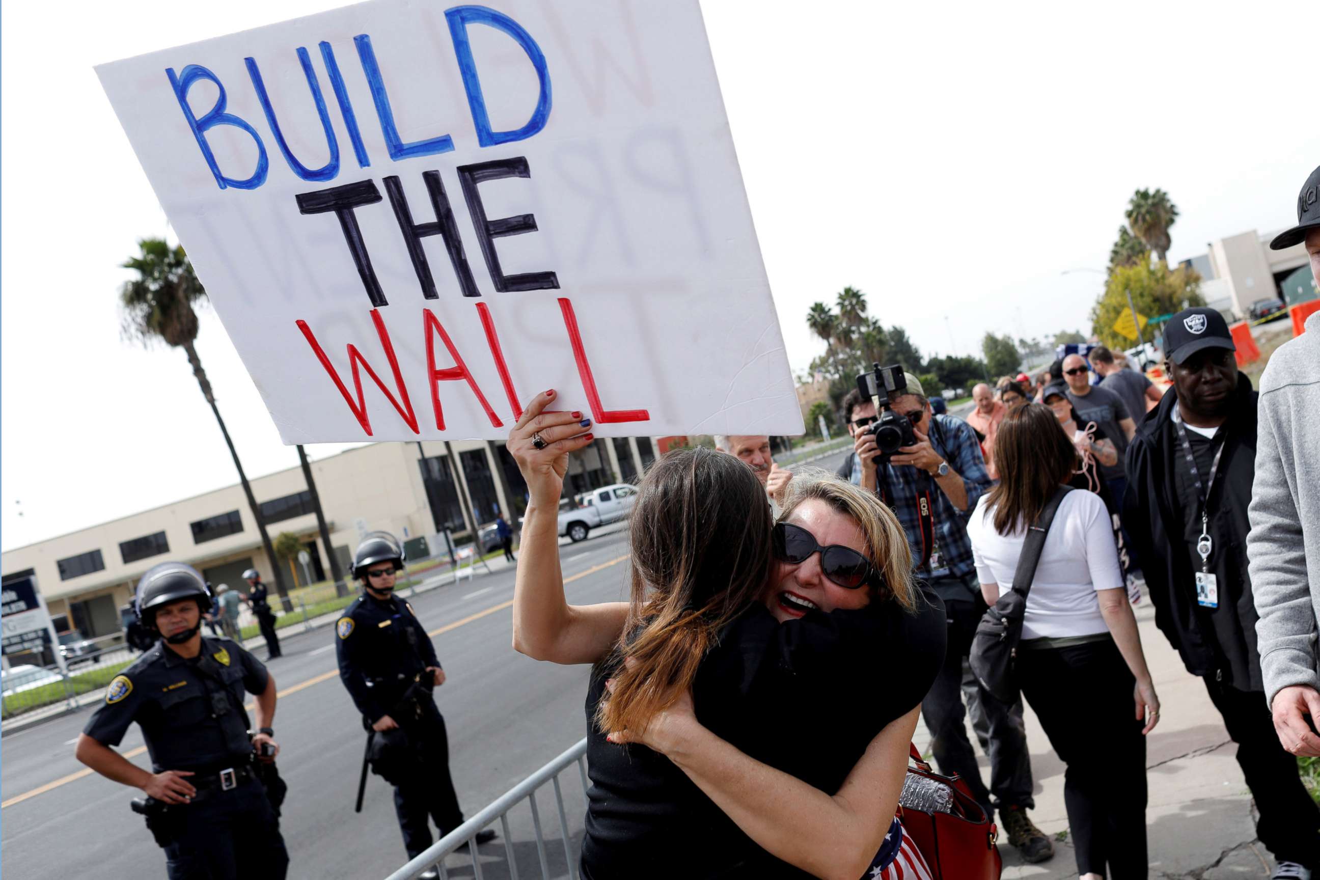 PHOTO: Supporters hug after President Donald Trump's motorcade drove past them following his viewing of border wall prototypes in San Diego, March 13, 2018.
