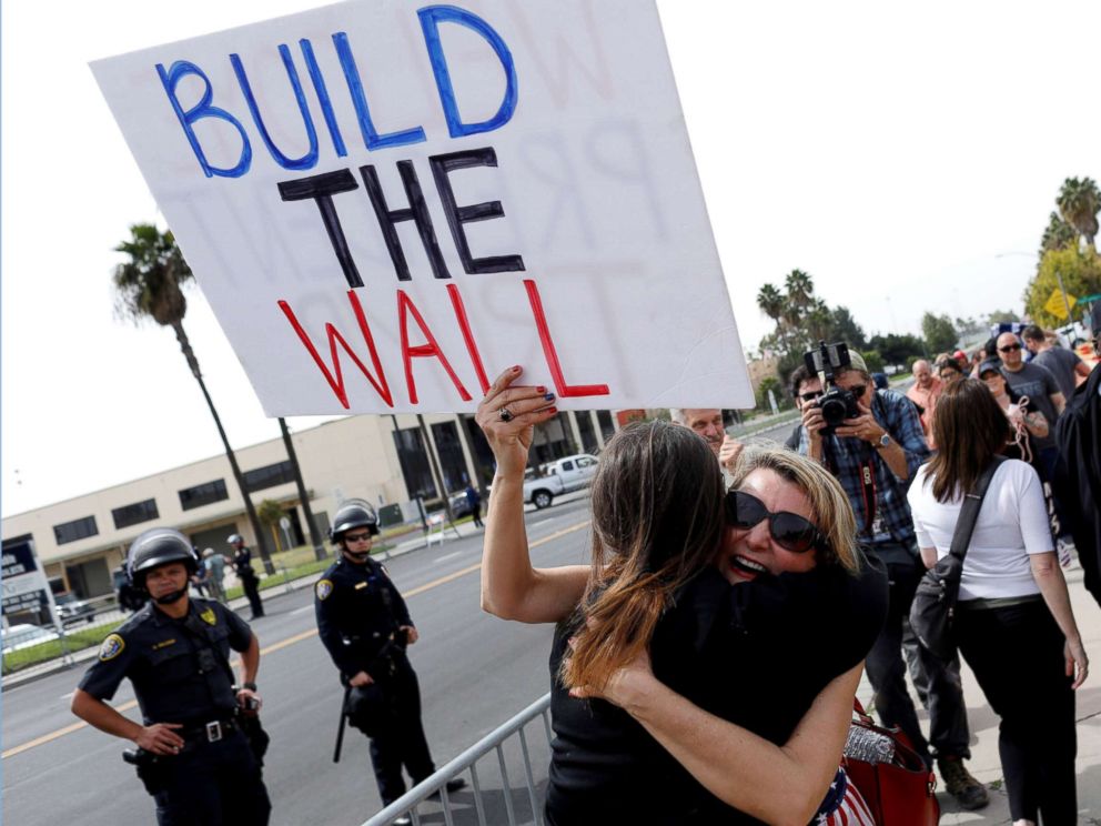 PHOTO: Supporters hug after President Donald Trumps motorcade drove past them following his viewing of border wall prototypes in San Diego, March 13, 2018.