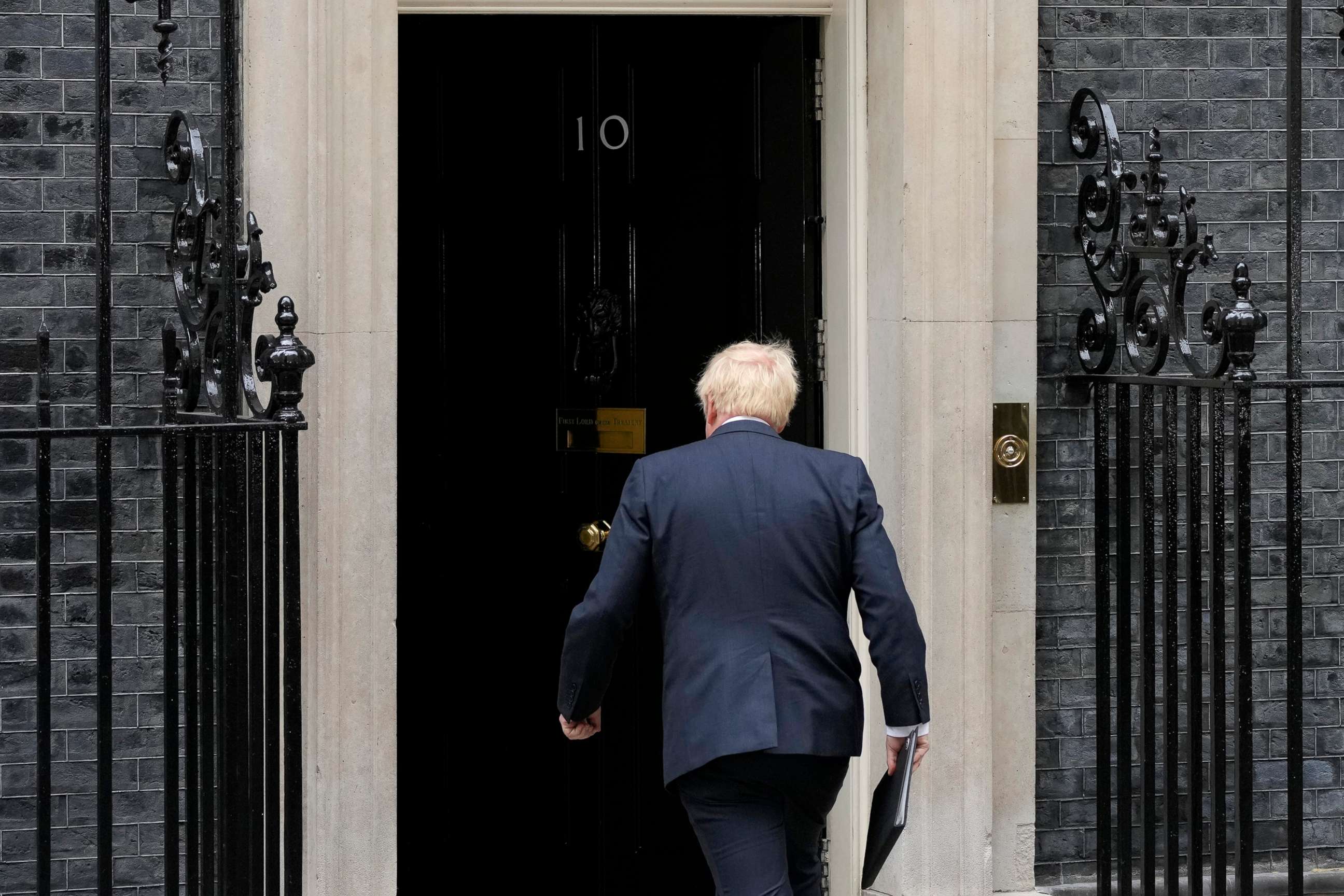 PHOTO: Prime Minister Boris Johnson walks back inside after reading a statement outside 10 Downing Street in London, formally resigning as Conservative Party leader, July 7, 2022.