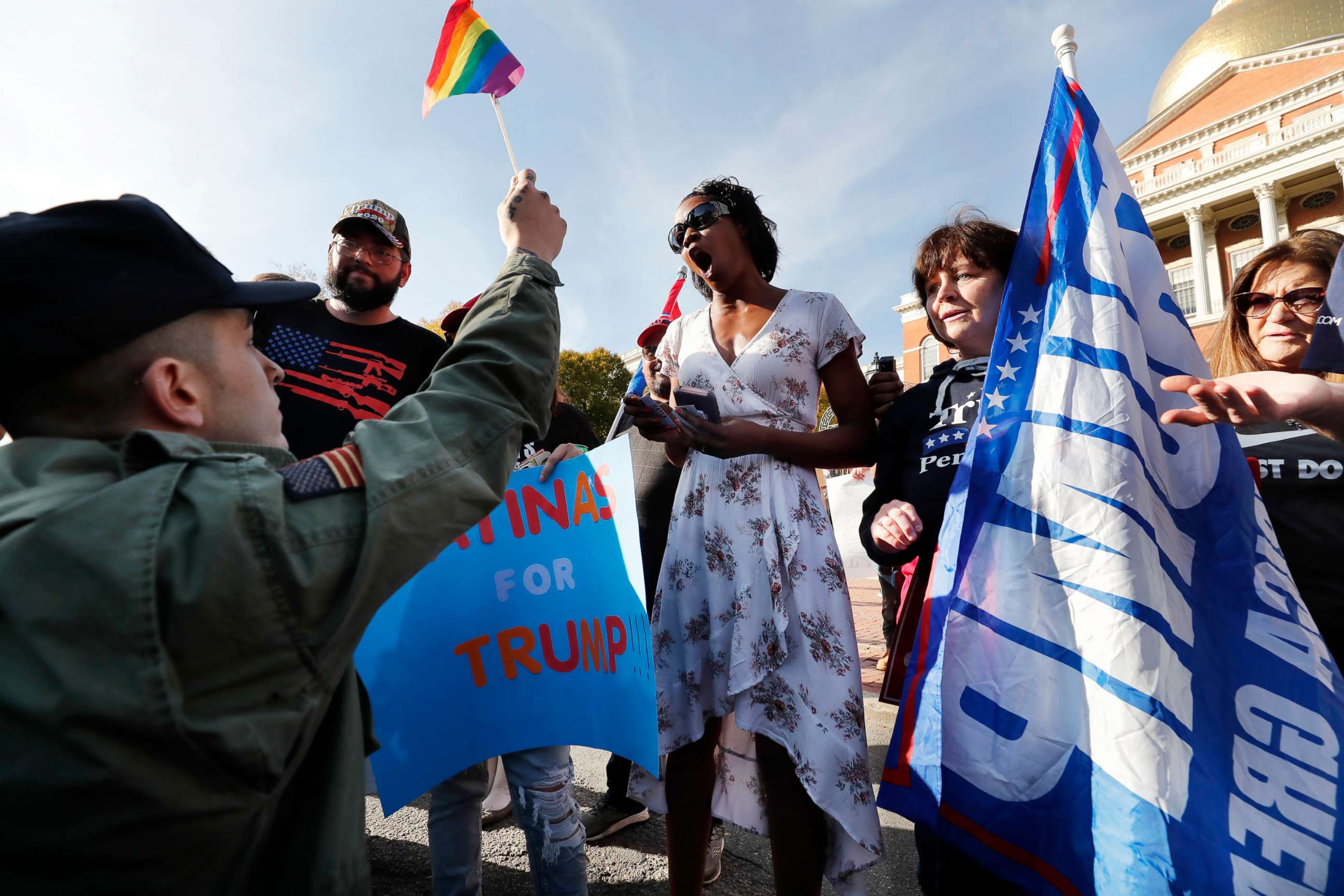 PHOTO: A supporter of President-elect Joe Biden, left, holds a rainbow flag in front of supporters of President Donald Trump outside the Statehouse, Nov. 7, 2020, in Boston.