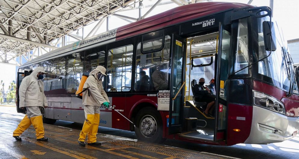 PHOTO: Members of a municipal sanitization crew use mixing of sodium hypochlorite and water to disinfect and eliminate viruses and bacteria from the bus terminals on May 25, 2020 in Sao Paulo.