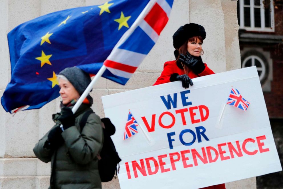 PHOTO: A pro-Brexit activist holds a placard reading We Voted For Independence as an anti-brexit campaigner waves an European Union and a Union flag outside the Houses of Parliament in London, Jan. 21, 2019.